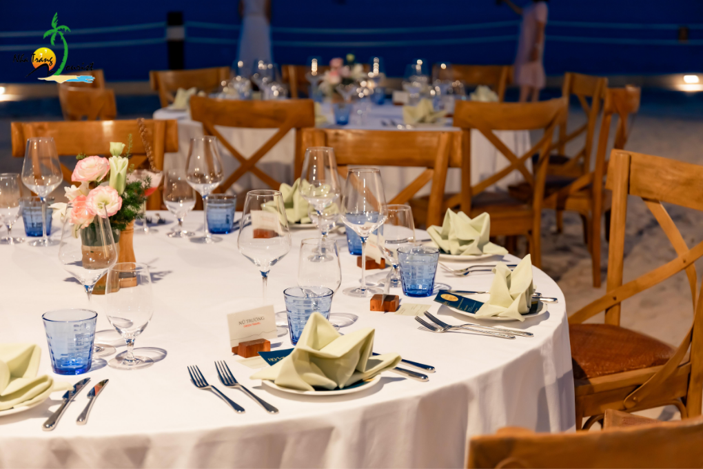 A dining table prepared with plates and floral decorations onboard a yacht, creating a setting for a meal at sea