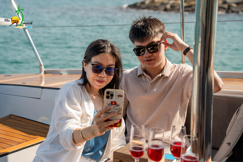 A mother and her son enjoying drinks together aboard a yacht, sharing a relaxed moment during their sea experience