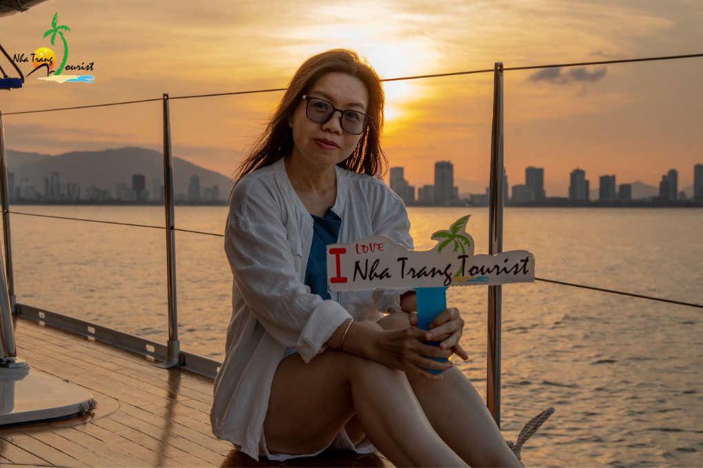 Guest relaxing aboard a yacht at sunset, with warm evening light and the coastal skyline in the background